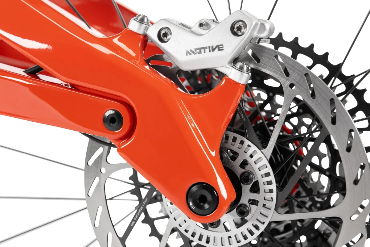Detailansicht des orangefarbenen Rahmens mit montiertem Bremssattel und Bremsscheibe des ROTWILD R.XX ULTIMATE Mountainbikes.
