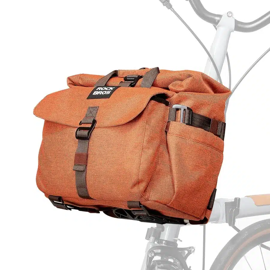 Orangefarbene ROCKBROS Fahrrad-Lenkertasche mit braunen Details und Schnallen, montiert an einem Brompton-Fahrrad.