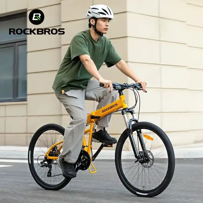 Ein Mann mit Helm fährt auf einem gelben ROCKBROS SGD Faltrad.