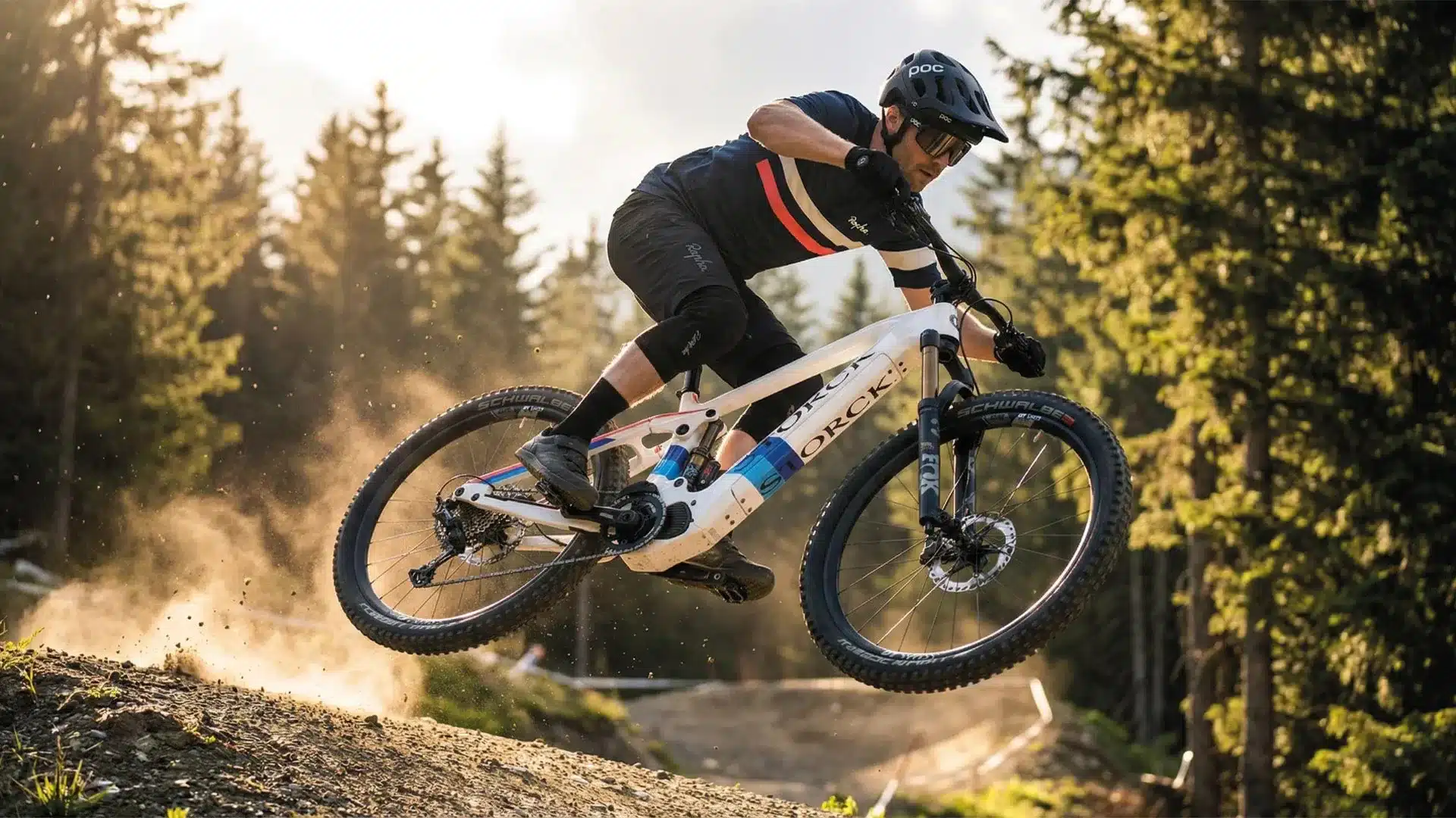 Ein Mann fährt ein weißes Storck E-Drenalin E-Mountainbike und macht einen Sprung auf einem Waldtrail.