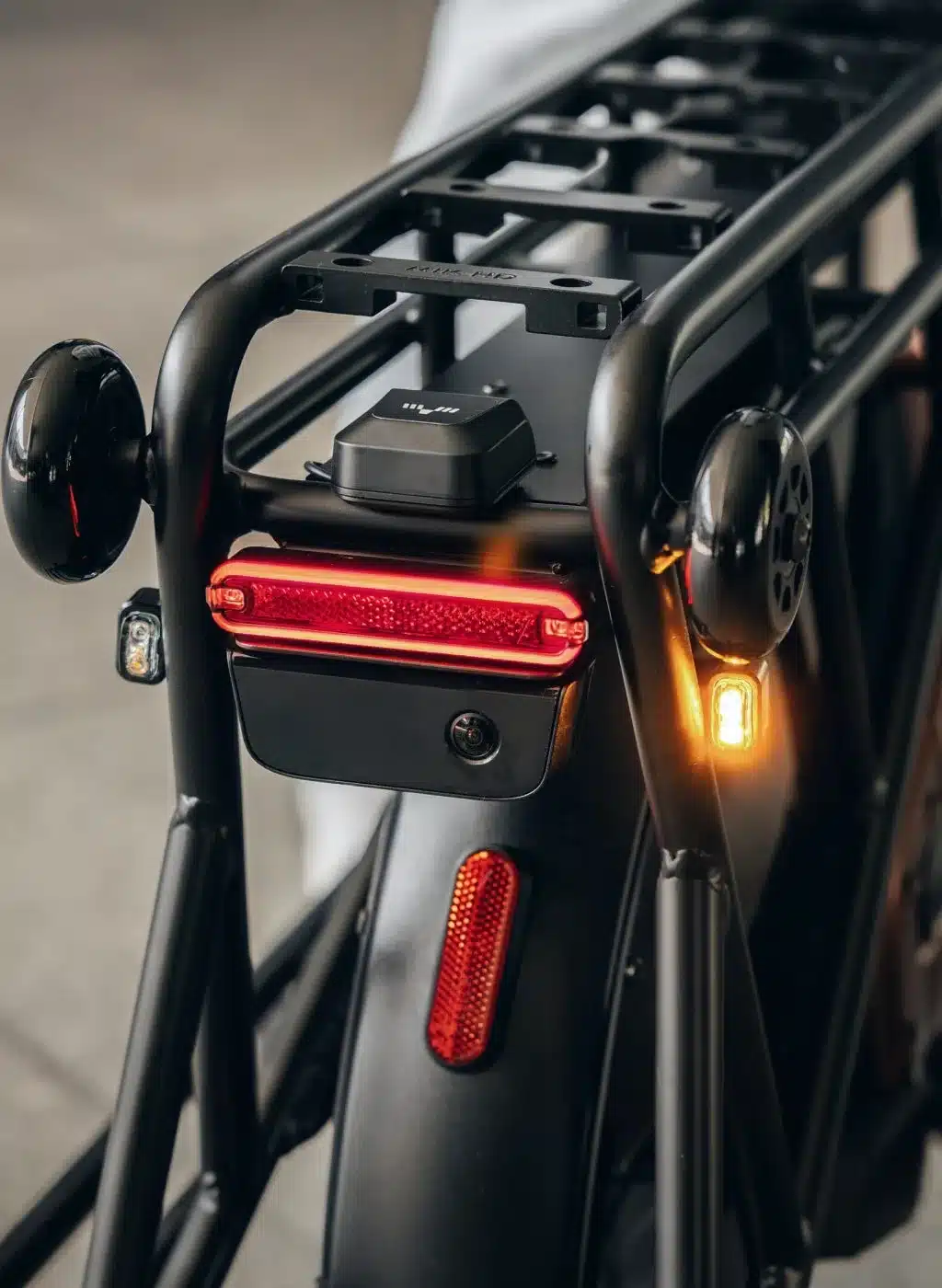 Detailaufnahme des TARRAN L1 Fahrrads mit Fokus auf Rücklicht, Blinker und Gepäckträger