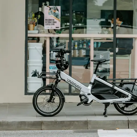 Das TARRAN L1 Longtail Fahrrad steht auf einem Gehweg vor einem Geschäft.