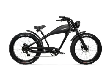 Seitenansicht eines schwarzen Varaneo Café Racer E-Bikes mit breiten Kenda Reifen, integriertem Akku im Tank-Design und runden Scheinwerfer.