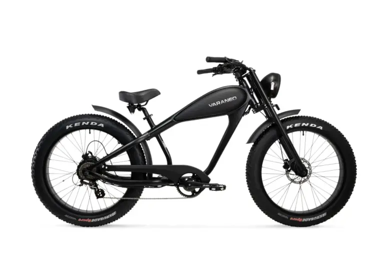 Seitenansicht eines schwarzen Varaneo Café Racer E-Bikes mit breiten Kenda Reifen, integriertem Akku im Tank-Design und runden Scheinwerfer.