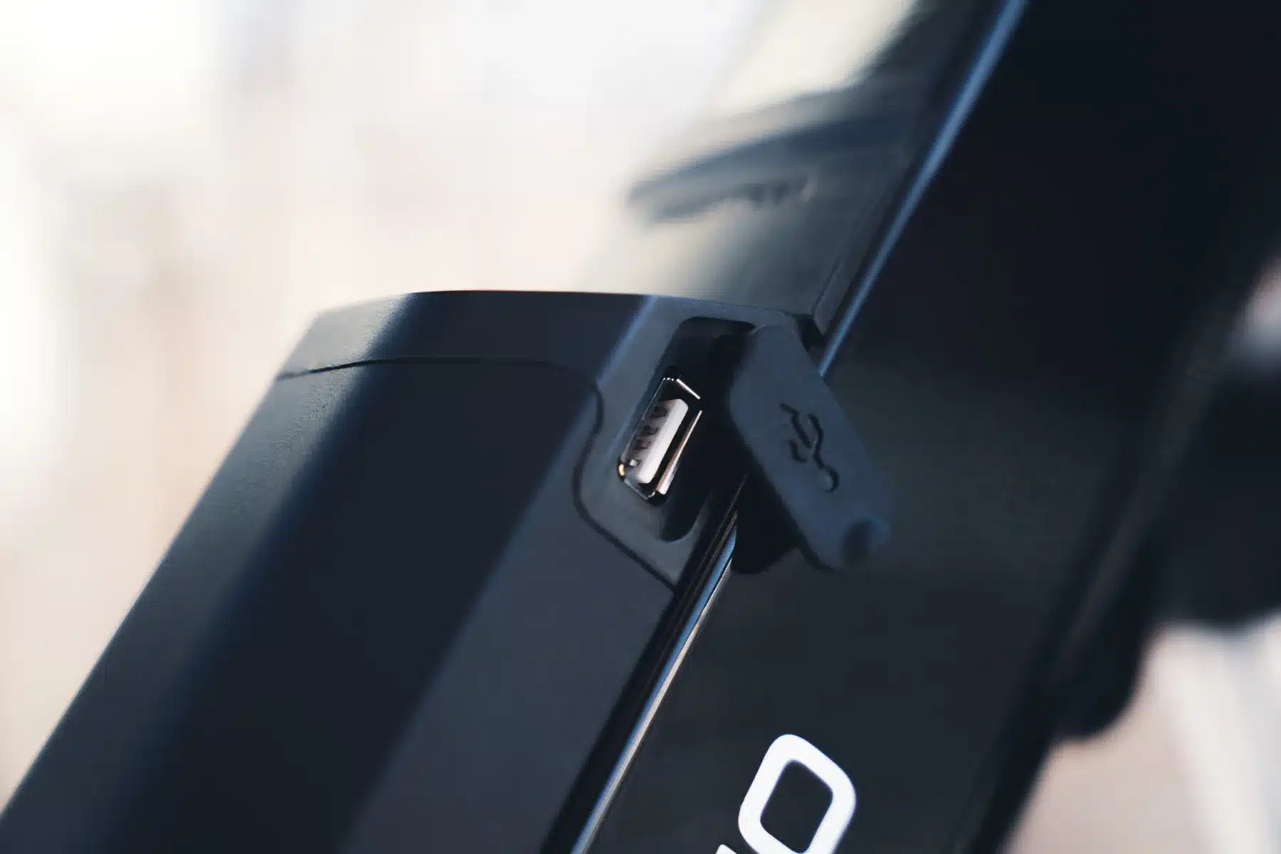 Detailansicht des USB-Ladeanschlusses an einem schwarzen E-Bike-Akku.
