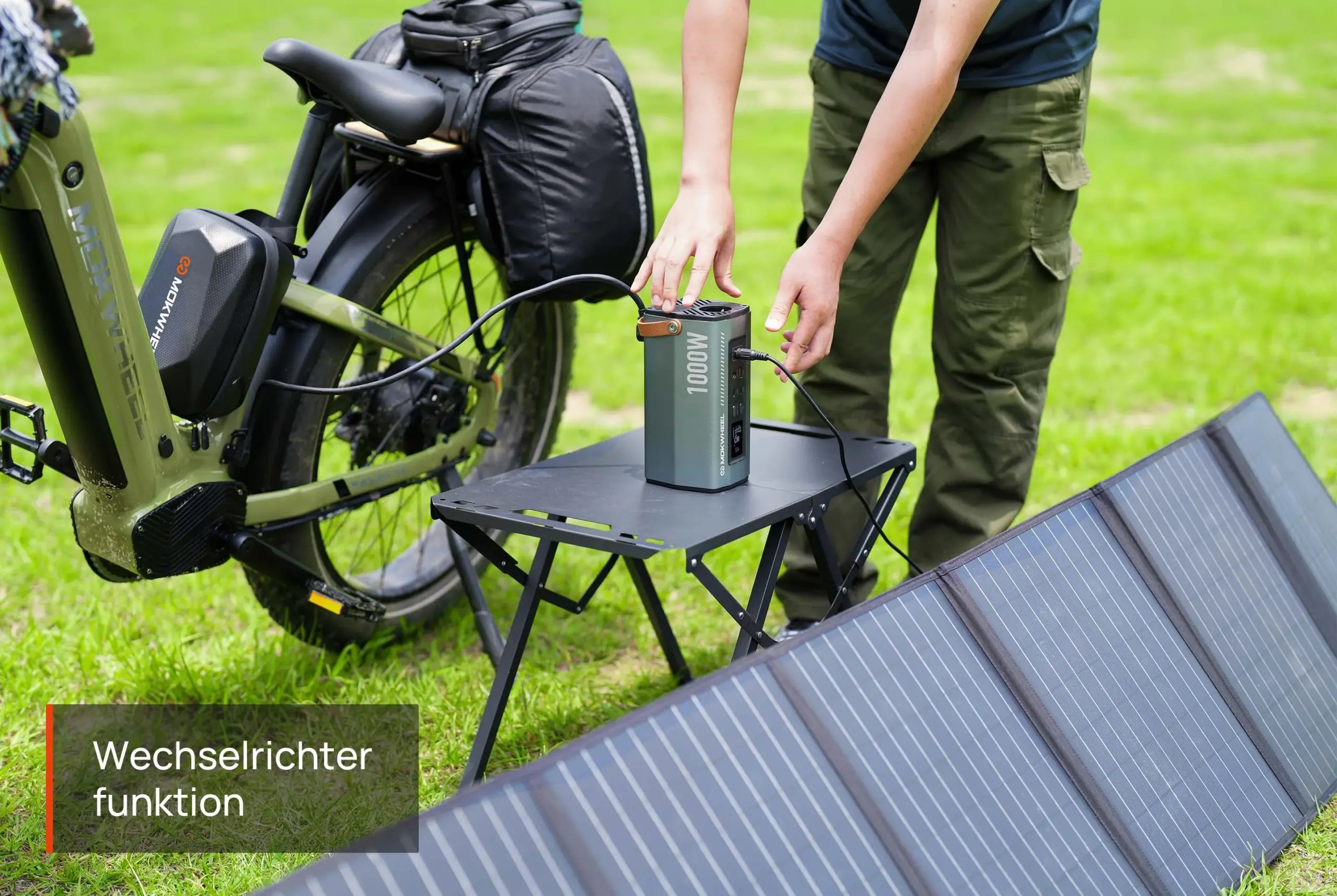 Ein E-Bike steht neben einer ausgeklappten Solarpanel-Anlage, während eine Person eine mobile Powerstation bedient.