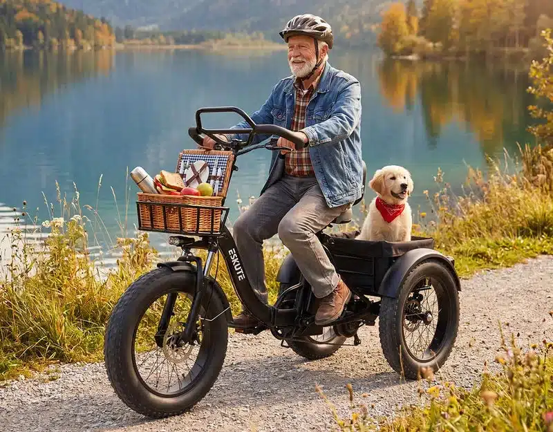 Mann mit Hund fährt Eskute T302 Pro E-Lastendreirad am See mit Picknickkorb