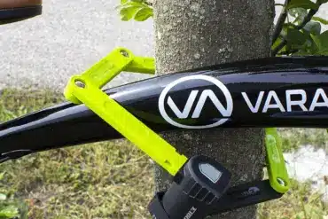 Fahrradschloss ETook ET 490L in Grün, das ein Fahrrad an einem Baum sichert