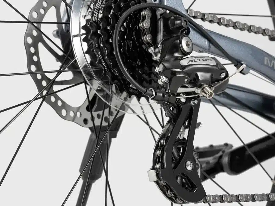 Nahaufnahme des Shimano Altus Schaltwerks und der 8-fach Kassette am Hinterrad eines MT200 27.5E Fahrrads, zusammen mit der Scheibenbremse.