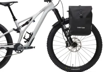 Aeroe Urban Pannier Bag, eine schwarze, wasserdichte Fahrradtasche, ist an der Vorderseite eines Mountainbikes montiert.