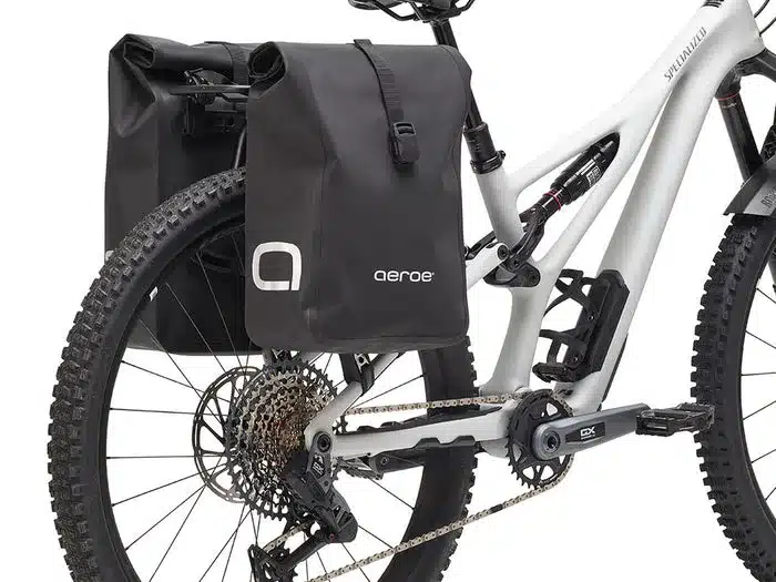 Detailaufnahme der Aeroe Urban Pannier Bag, einer schwarzen Fahrradtasche, die seitlich an der Hinterradaufhängung eines Mountainbikes befestigt ist.